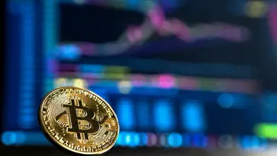 Bitcoin vor einem Handelsbildschirm als Symbolbild für KuCoin